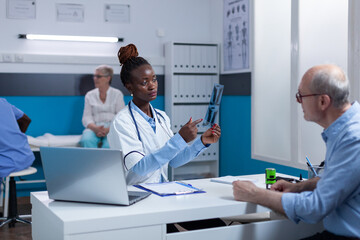 Healthcare radiology expert observing x-ray image scan and analyzing results. Clinic doctor specialist examining radiography scan image and prescribing special treatment.