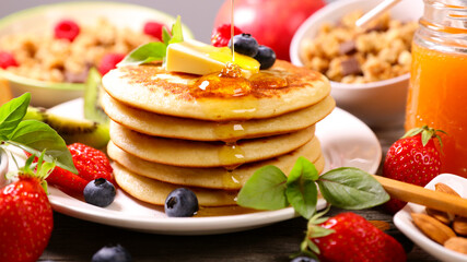 pancakes with berries fruits,  butter and maple syrup