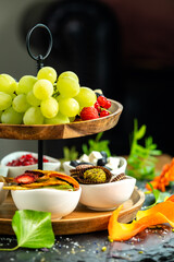 Healthy organic breakfast fruit selection with grapes, strawberry and date sweets