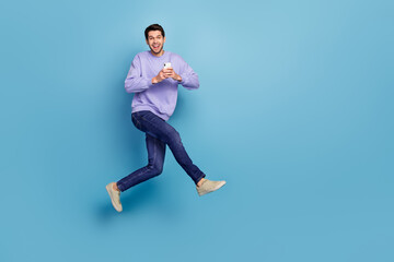 Fototapeta na wymiar Photo of cheerful guy jump use gadget rush eshop application adverts isolated blue pastel color background