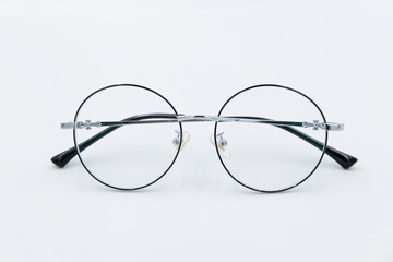 Selective focus round eyeglasses with silver rim. Isolated white background.