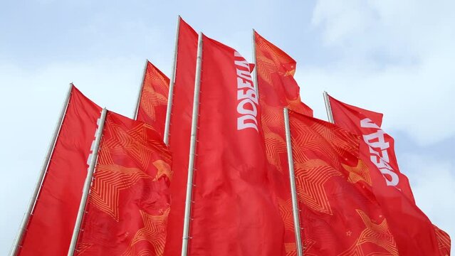 Group of red flags with Russian Pobeda word (means Victory) swings on flagpoles. Clouds on the sky in the background. 4K resolution real time video. Russian Victory day holiday theme.