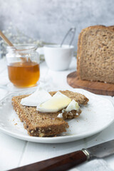 Healthy breakfast with wholemeal bread, fresh goat cheese and raw honey. A delicious breakfast.