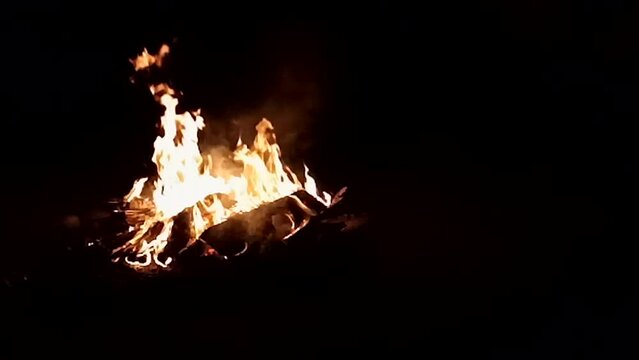 Big bonfire with sparks and particles in dark forest slow motion
