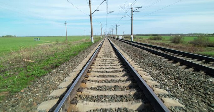 Railway track view in motion. Rails for trains. Railway lines in sunny weather.