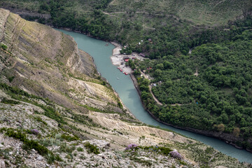 Fototapeta na wymiar deep gorge with a river flowing below on a spring sunny day in Dagestan