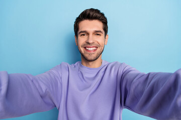 Obraz premium Photo of cute millennial brunet guy do selfie wear sweatshirt isolated on blue color background