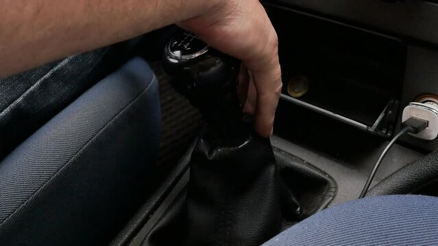 the driver's hand shifts the lever of a manual transmission while driving a car. Close up, Slow motion