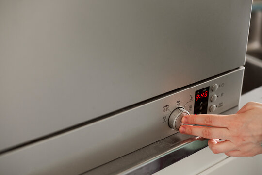 Woman's hand starting dishwasher