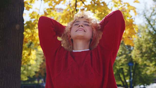 Attractive carefree blond girl enjoys her time in park autumn medium closeup copy space . High quality photo