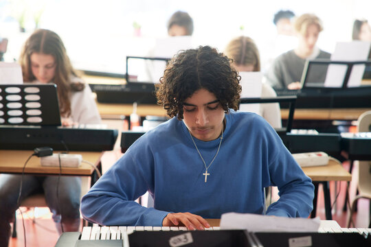 Teenagers attending keyboard lesson