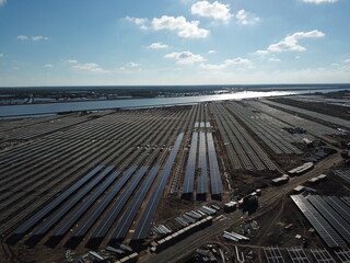 Solar farm under construction with solar panels and empty frames in the background - Green energy and sustainable development concept