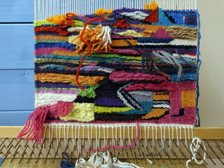 Weaving colorful tapestry on a loom, manufacturing