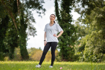 A young fit woman in sports clothes relax at the summer park. Wellness