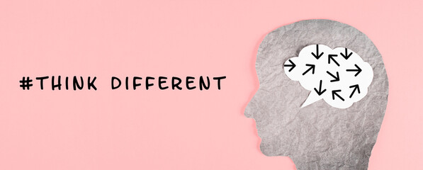 Think different stands on the pink background, head with brain, being a nonconformist, standing out...