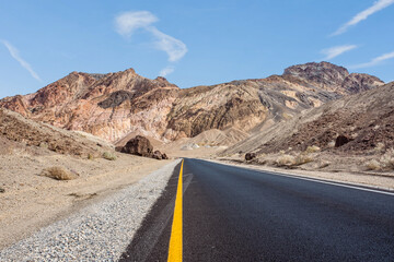 beautiful landscape of a road through death valley usa with a cloud appearing to point the direction