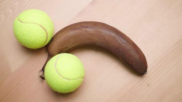 Adding two tennis balls beside the black banana on table 4K