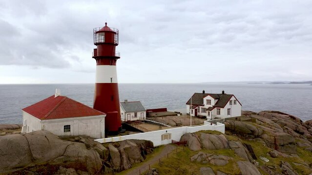 Beautiful aerial of Ryvingen lighthouse and lighthousekeepers home - Ascending aerial showing beautiful island with traditional lighthouse at Norway southern coastline with north sea in background