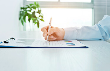 Close up of businesswoman hand writing on paper in office