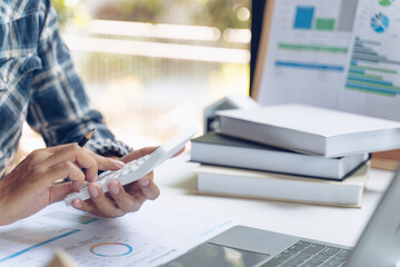 Businessman using calculator and laptop computer for calculating with finance paper, tax, accounting. Finance concept.