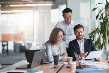 businessmen discussing documents with graphs and charts in a modern office during meeting. 