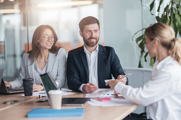 Confident and successful team. Group of people are working together in office. Blurred background