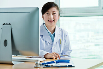 Asian woman doctor working on computer