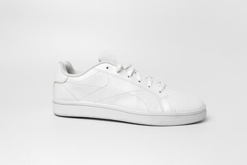 Side view of white sneaker isolated on white background for cutting out. Sportive pair of shoes for mockup. Fashionable stylish sports casual shoes.