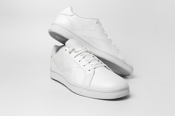 New pair of white sneakers isolated on white background for cutting out. Sportive pair of shoes for...