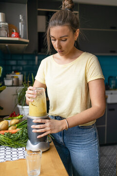 Young woman making a healthy smoothie for breakfast