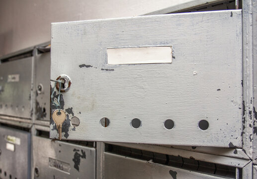 old open silver mailbox on the wall.