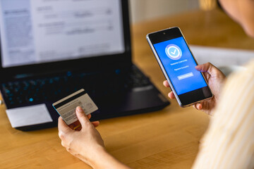 Young woman paying bills with credit card online