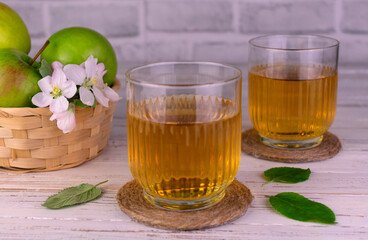 Two glasses of apple juice from green apples.
