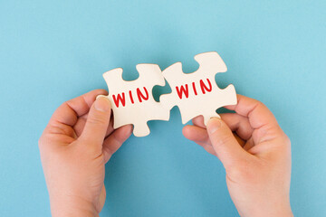 The word win is standing on puzzle parts, problem solving, winner mindset, business and education...