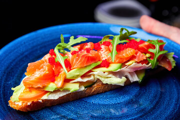 Bruschetta with salmon, avocado and flying fish caviar