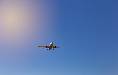 Fototapeta na wymiar Airplane flying on the blue sky background.