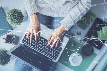 Double exposure of woman hands working on computer and forex chart hologram drawing. Top View. Financial analysis concept.