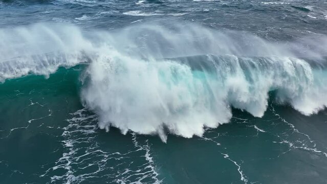 Aerial shot of powerful tsunami wave. Slow motion of big sea or ocean surf wave crashing. UD, 4K.