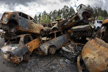 Fototapeta na wymiar Burned civilian car. Stacked vehicles. War in Ukraine. 