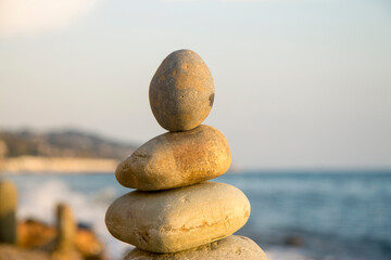 Balanced stones on the seashore summertime and sea background