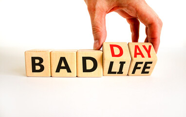 Bad day or life symbol. Businessman turns wooden cubes and changes concept words Bad life to Bad day. Beautiful white table white background. Business and bad day or life concept. Copy space.