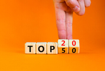 From Top 50 to 20 symbol. Businessman turns wooden cubes and changes concept words Top 50 to Top 20. Beautiful orange table orange background. Business and from Top 50 to Top 20 concept. Copy space.