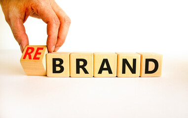 Time to rebrand symbol. Businessman turns wooden cubes and changes the concept word Brand to Rebrand. Beautiful white table white background. Business brand or rebrand concept. Copy space.