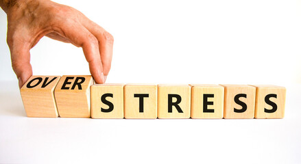 Over stress symbol. Psychologist turns wooden cubes and changes the concept word Stress to Over stress. Beautiful white table white background, copy space. Psychlogical over stress concept.