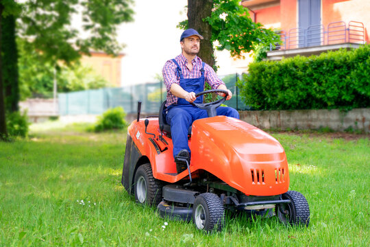One gardener driving riding lawn mower garden