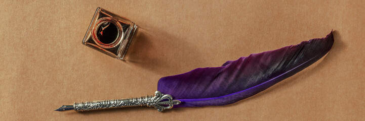Feather quill pen with an old inkwell panorama, shot from the top on old paper