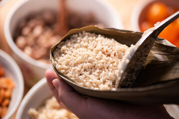 Making zongzi food - preparing and wrapping Chinese rice dumpling.