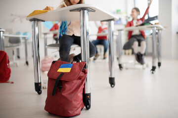 Children in classrom, detail on backpack of Ukrainian student, concept of enrolling Ukrainian kids...