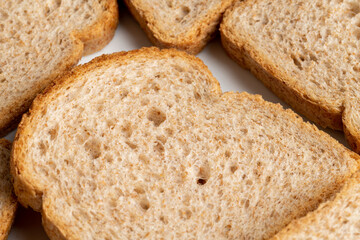 Slices of brown bread baked from wheat flour on a white plate.