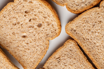 Slices of brown bread baked from wheat flour on a white plate.